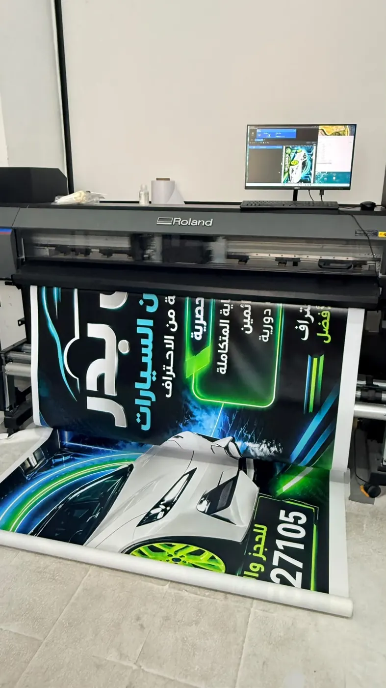 Roland printer printing a car-service banner at Al Reef